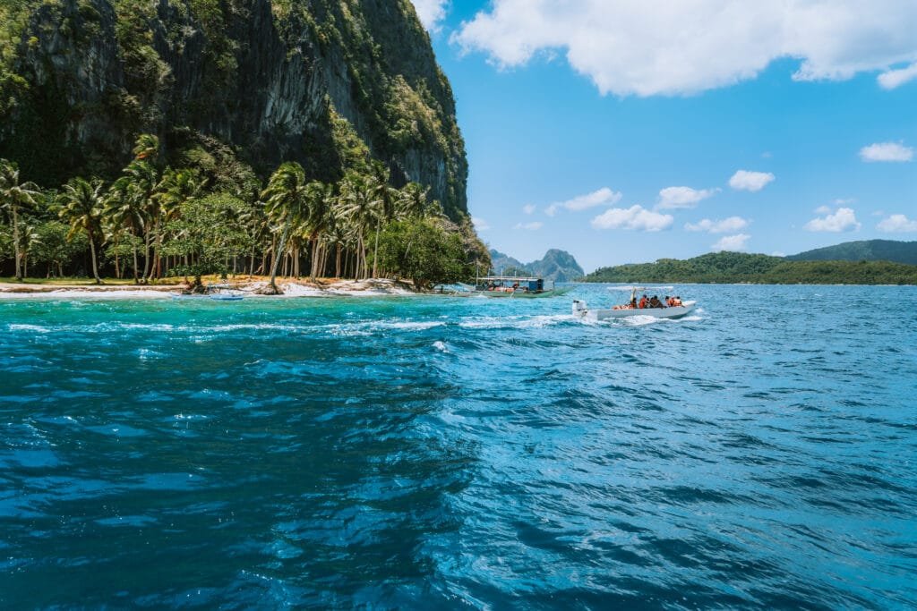 Boat with tourists on ipil beach of exotic island on hopping tour, Bacuit archipelago, El Nido, Palawan , Philippines Boat with tourists on ipil beach of exotic island on hopping tour, Bacuit archipelago, El Nido, Palawan , Philippines